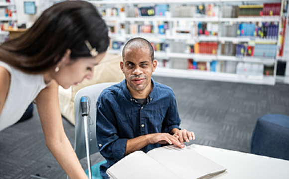 A blind man talking with a female colleague
